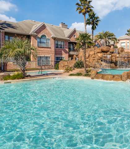 a large swimming pool with apartments in the background