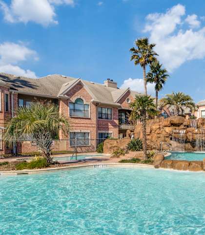 a large swimming pool with apartments in the background