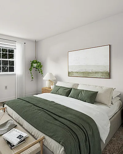 Elegant bedroom with plush green accents, large windows offering abundant natural light, and modern decor.