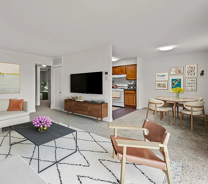 Inviting open-plan living space with cozy seating, modern decor, and a stylish dining area leading to a charming kitchen.