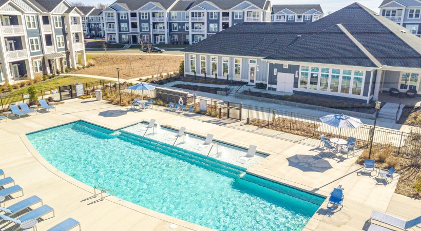 Outdoor swimming pool with lounge seating at Madison Farms apartments near Concord Mills Charlotte NC.