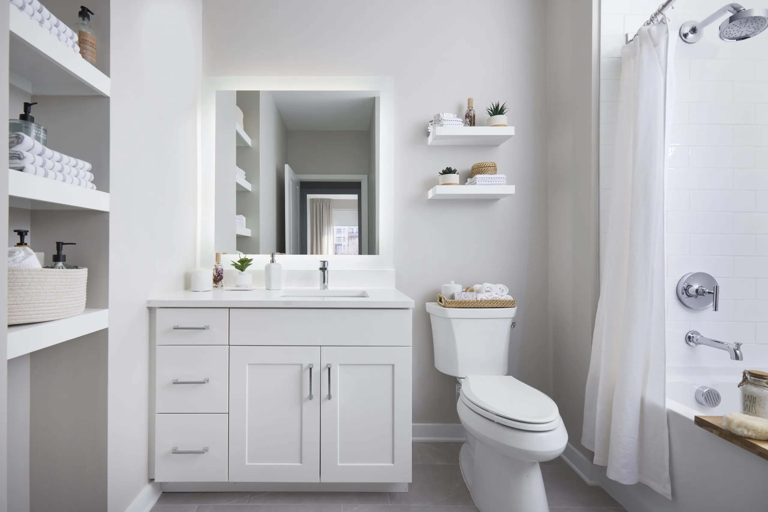 Bathroom with built in storage and backlit mirror