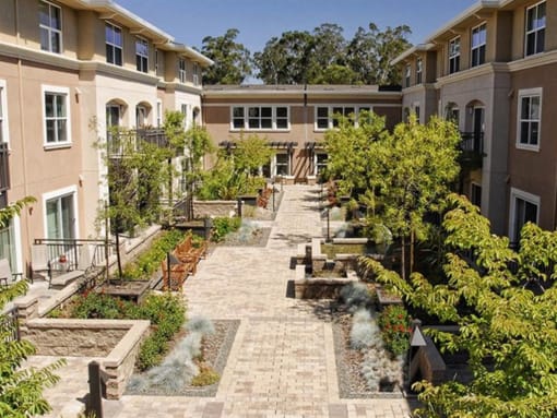 Dog-Friendly Apartments in Novato CA - Millworks - Courtyard Garden with Benches, Seating Area, Fountains, and Lush Greenery.