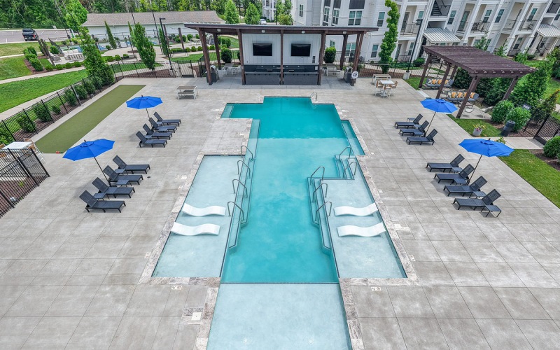 pool with lounge seating and umbrellas surrounding a pool