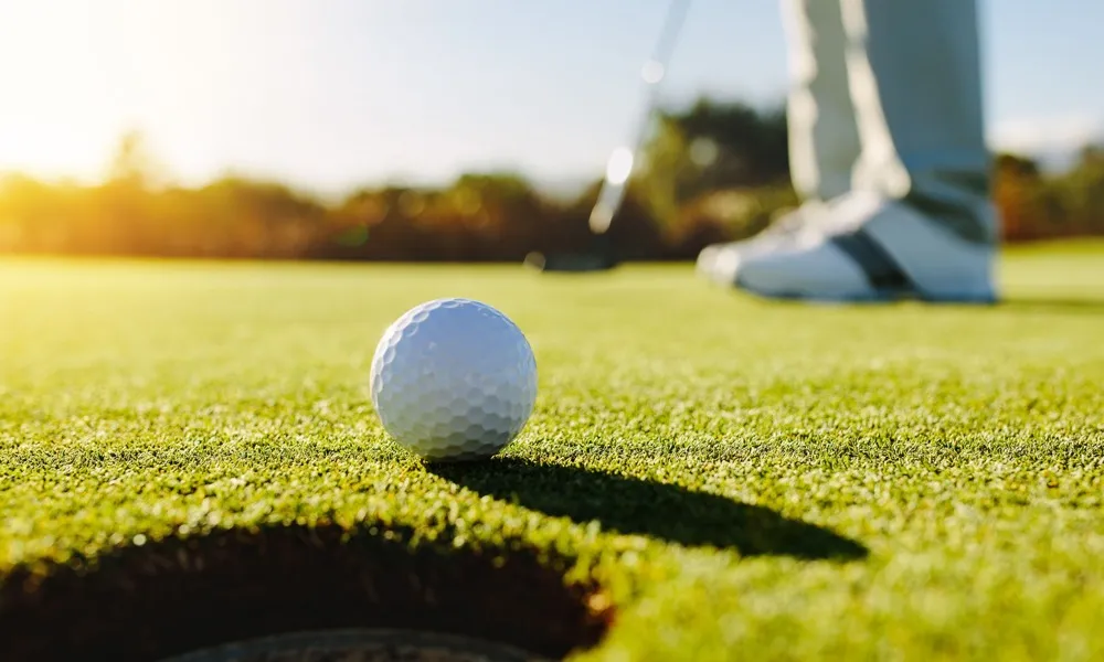 close up of golfer putting a golf ball