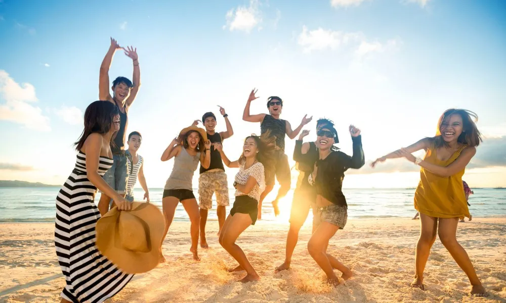 group of people jumping in air at beach