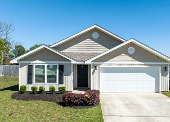 a house with a white garage door and a lawn