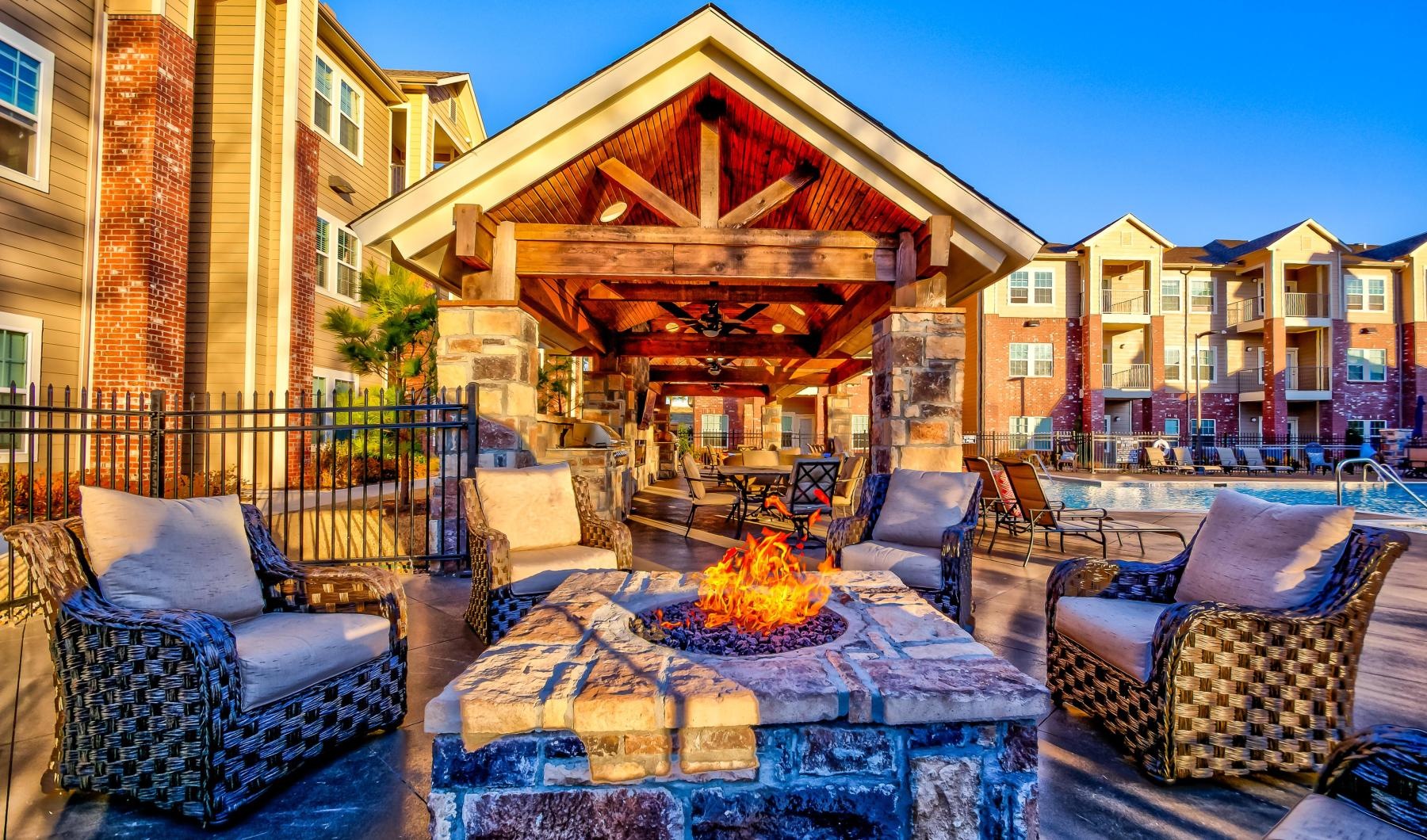 a patio with a fire pit and chairs