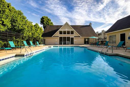 Resort style swimming pool and clubhouse at Sugar Creek Apartments in Winston Salem NC with outdoor lounge seating