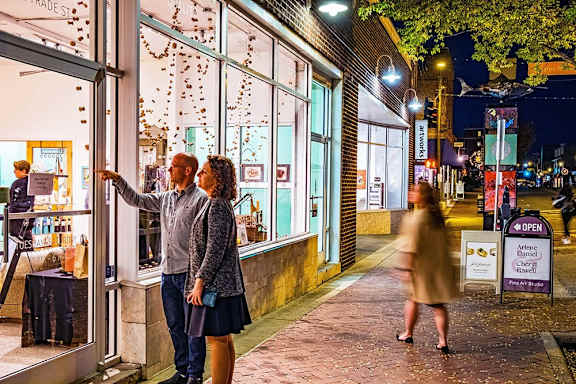 Couple exploring shops in the Winston-Salem Arts District at night near Sugar Creek Apartments with local dining, galleries, and downtown entertainment.