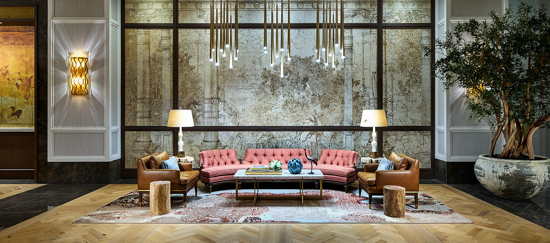 Luxurious apartment lobby with elegant chandeliers, plush seating, and sophisticated decor creating a warm, inviting atmosphere.