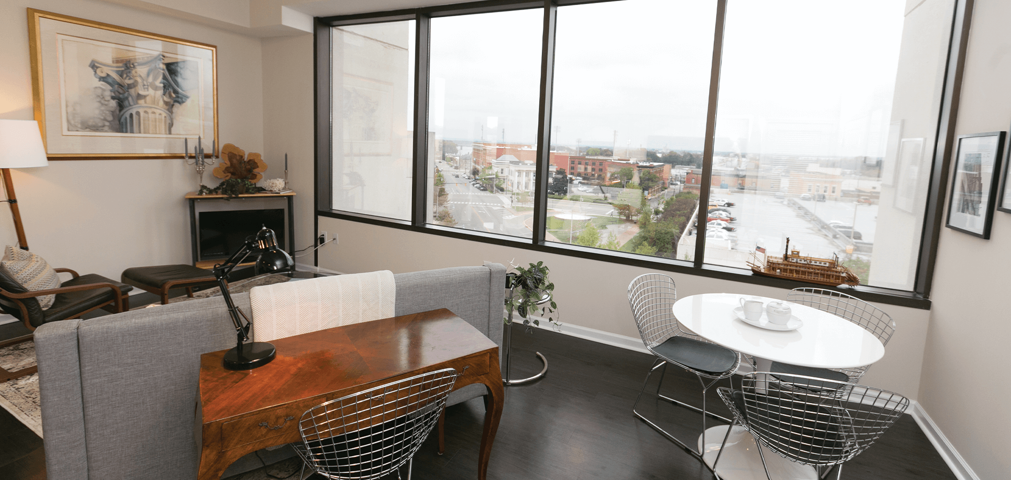 Living room view of the 40 four building with large window, hardwood floors and neutral paint color