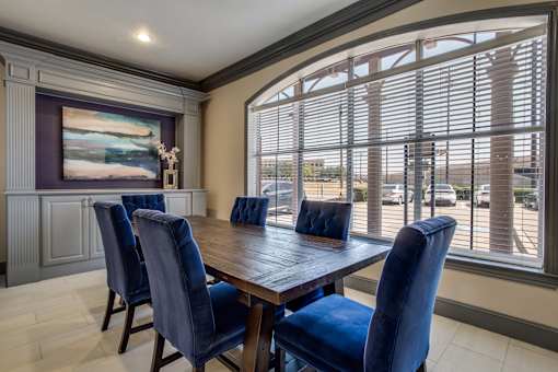 A dining room with a wooden table and blue chairs.