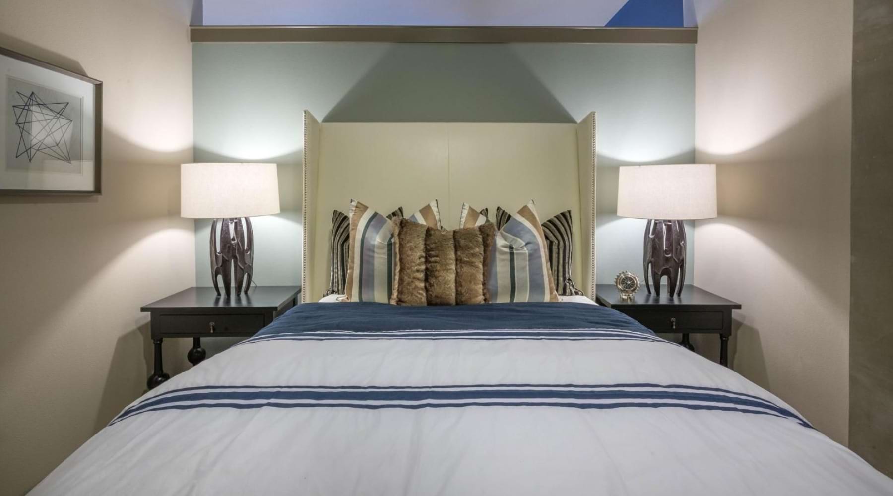 a bedroom with a bed and side tables with lamps
