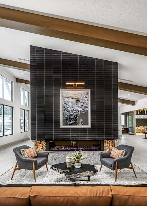 A modern living room with a fireplace and a large painting above it.