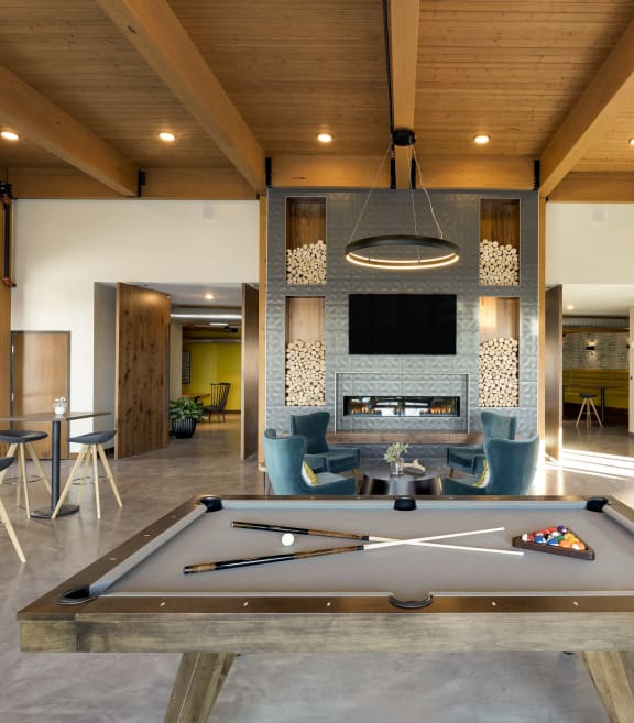 a living room with a pool table and a fireplace