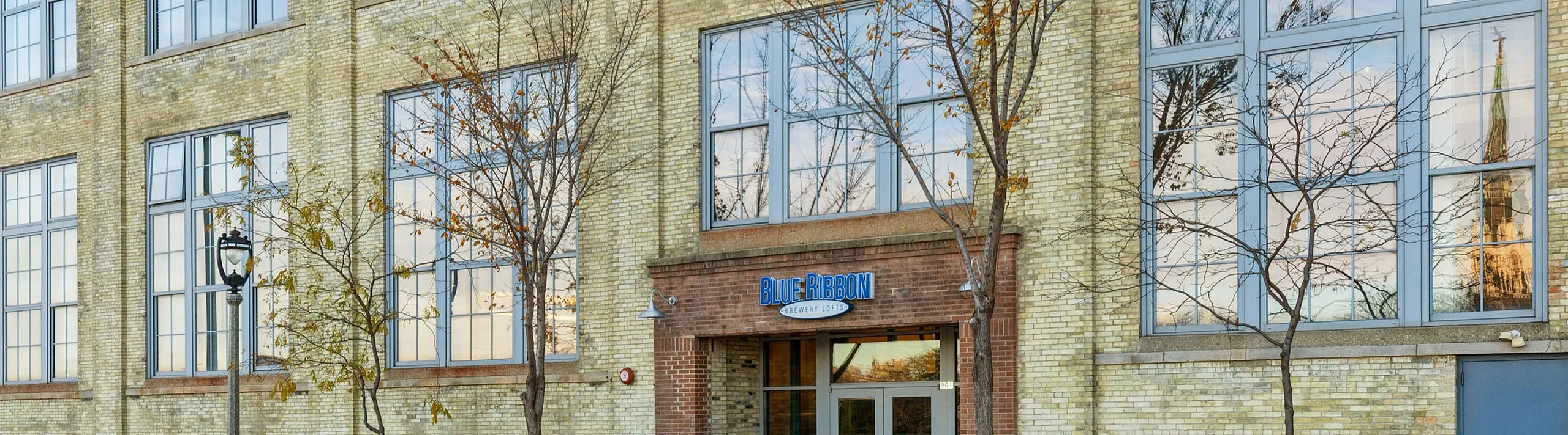 Historic brick building with large windows, showcasing a charming blend of classic architecture and modern design, ideal for urban living.