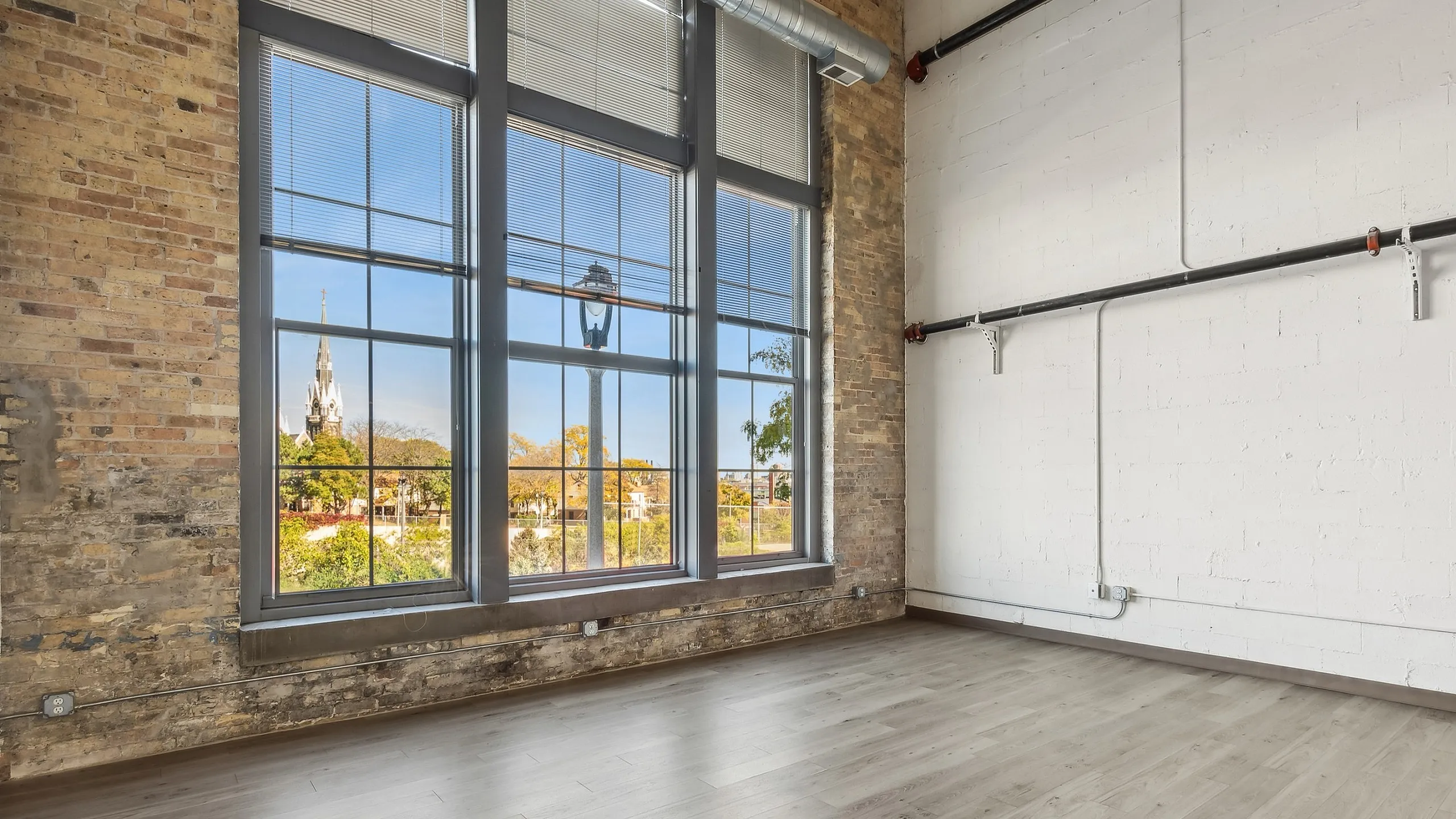 Chic loft with expansive windows and exposed brick, offering stunning views and abundant natural light.