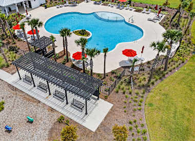 A pool with a black roof and red umbrellas.