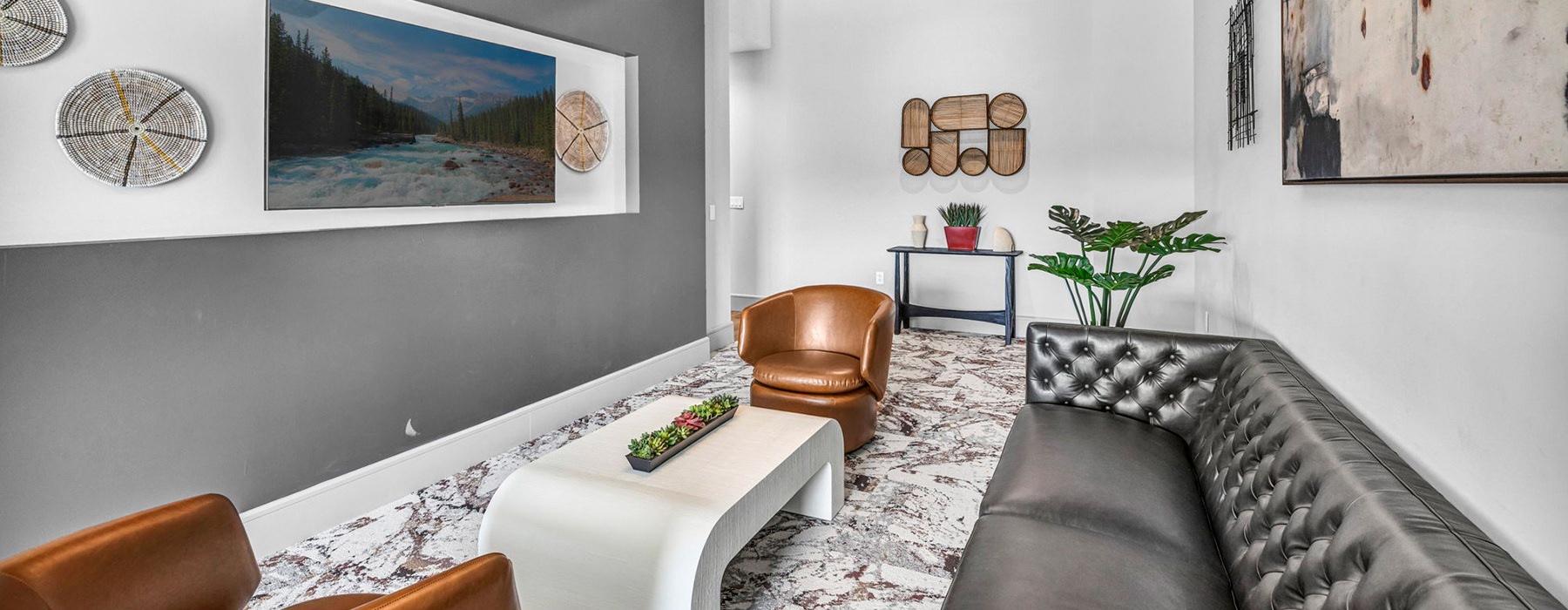 Spacious and well lit living room with wood floors and a large window with access to the kitchen