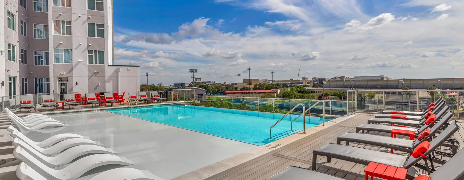 Large sparkling pool with large pool deck and lounge chairs at Haven at Elgin luxury pet friendly apartments in Houston, TX.