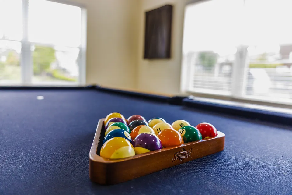 Inviting game room with a sleek billiard table and vibrant pool balls, perfect for entertainment and relaxation.