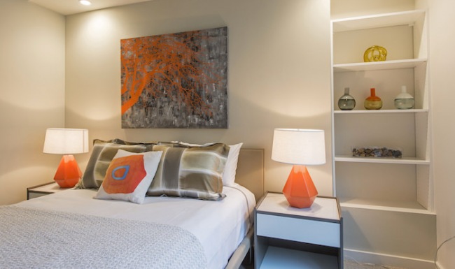 Large well lit bedroom with plush carpet floors and large windows.