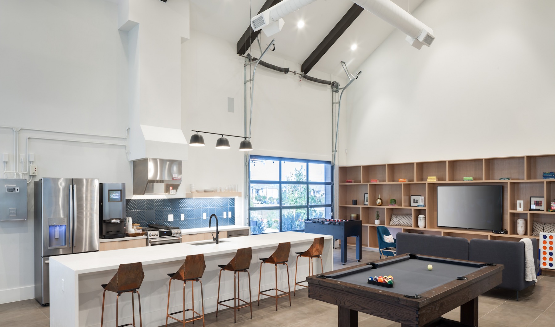 Resident Clubroom With Interior Glass Garage Doors At Abacus Alamo Ranch Apartments