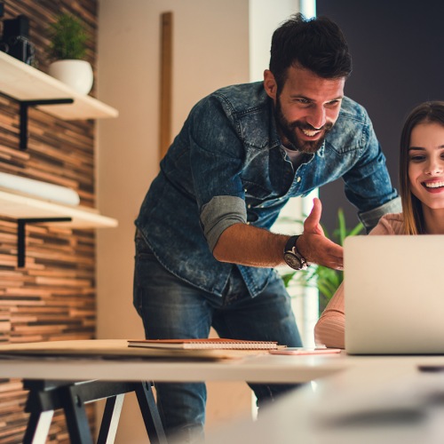 Young man and woman looking at computer together