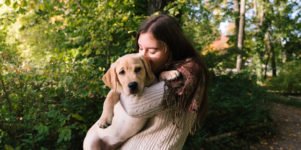 Happy resident and her puppy on a beautiful day at a park near The Fredd Townhomes in San Antonio, Texas