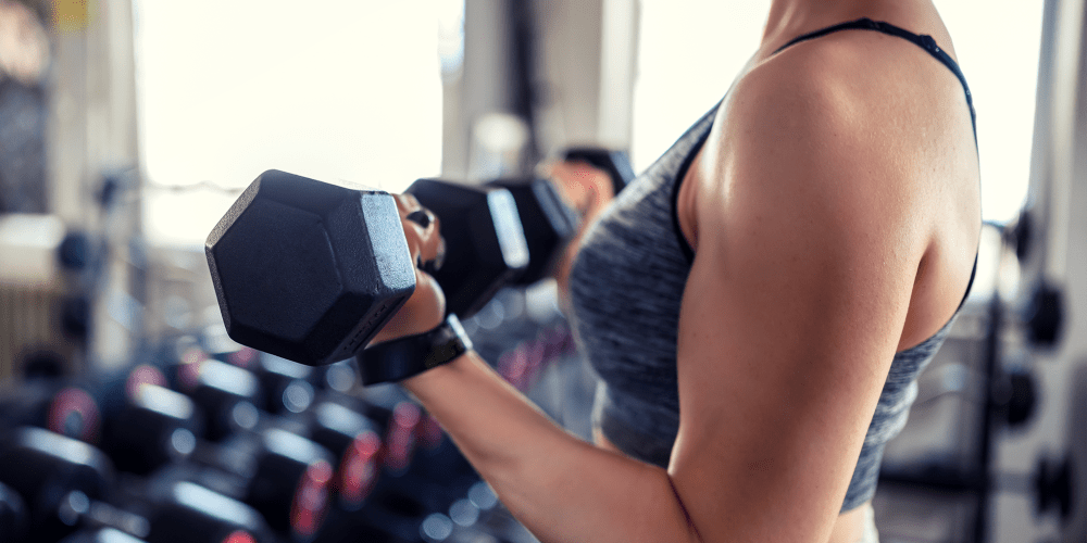Resident lifting weights in the fitness center at The Fredd Townhomes in San Antonio, Texas