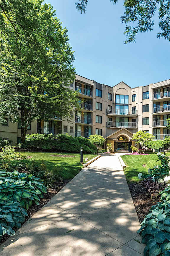 A pathway leads to a building with a green lawn on either side.