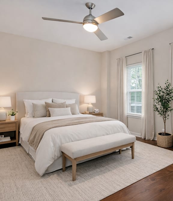 A bedroom with a bed, nightstands, and a ceiling fan.