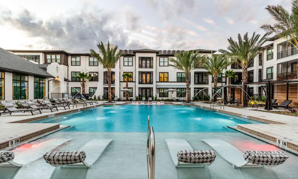 Swimming pool with lounge chairs and apartment buildings at Brisa at St. Augustine in St. Augustine, Florida