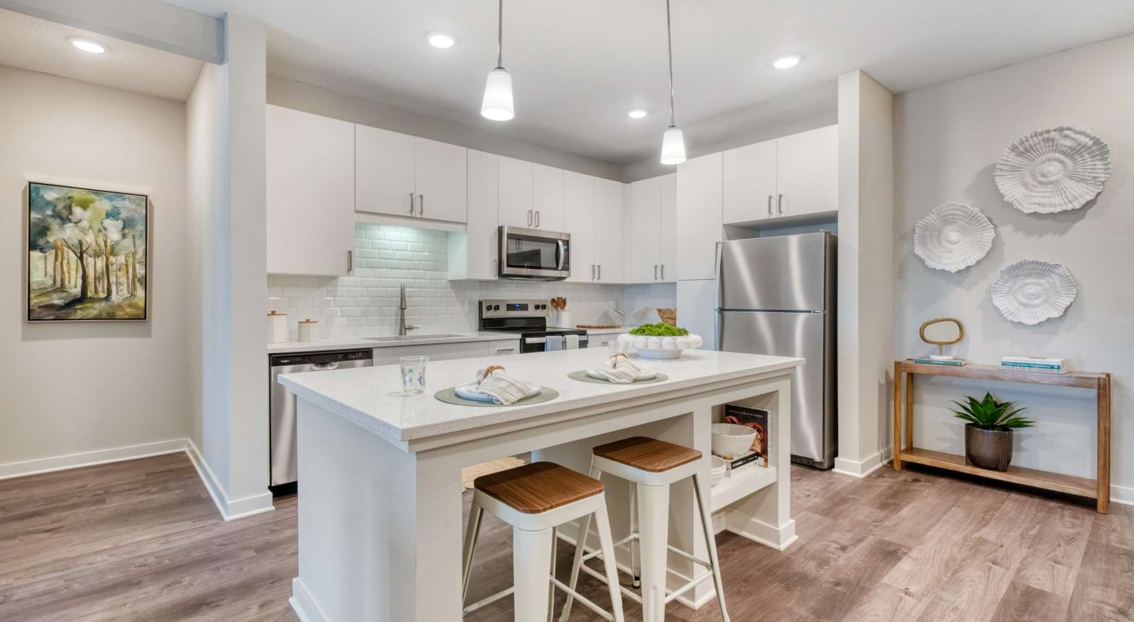 a kitchen with white cabinets and islands