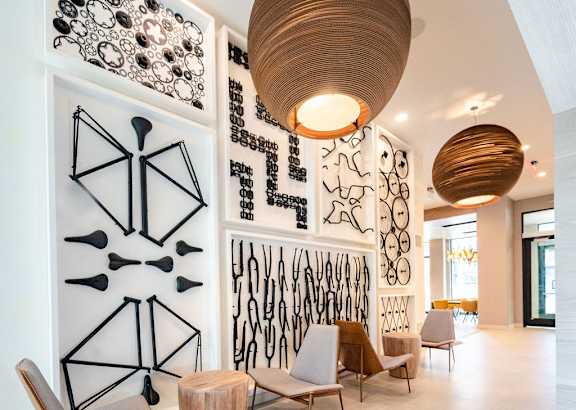 the lobby of a hotel with chairs and tables and a chandelier