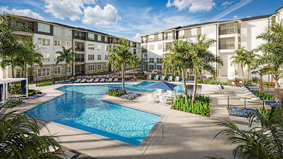 A large swimming pool surrounded by palm trees and lounge chairs.