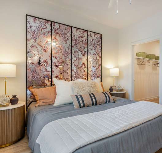 A bedroom with a large bed and a floral wallpaper.