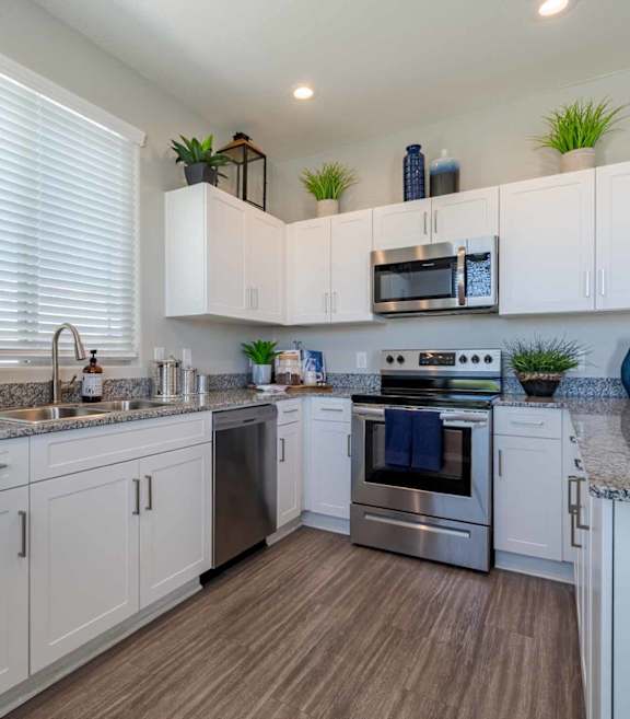 Modern kitchen with white cabinets and granite countertops at Vistoria On Mountain View Apartments, Surprise, 85374