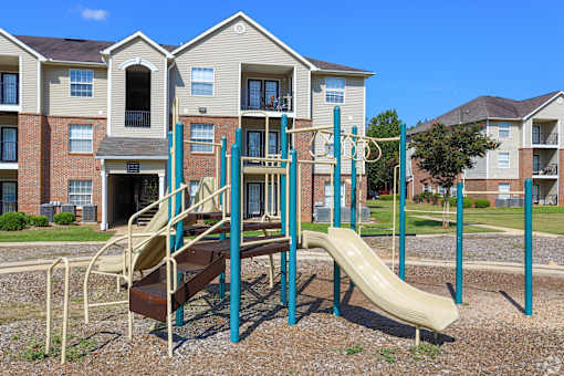an empty playground in front of an apartment building
