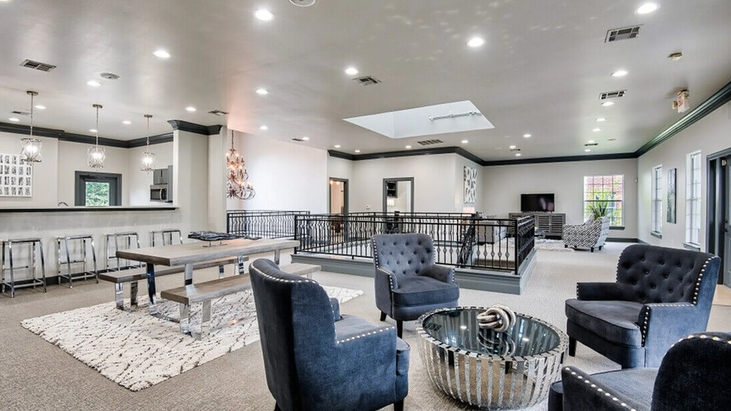 Spacious and elegant open-concept living area with plush seating, stylish lighting, and a modern kitchen bar, perfect for entertaining in style.