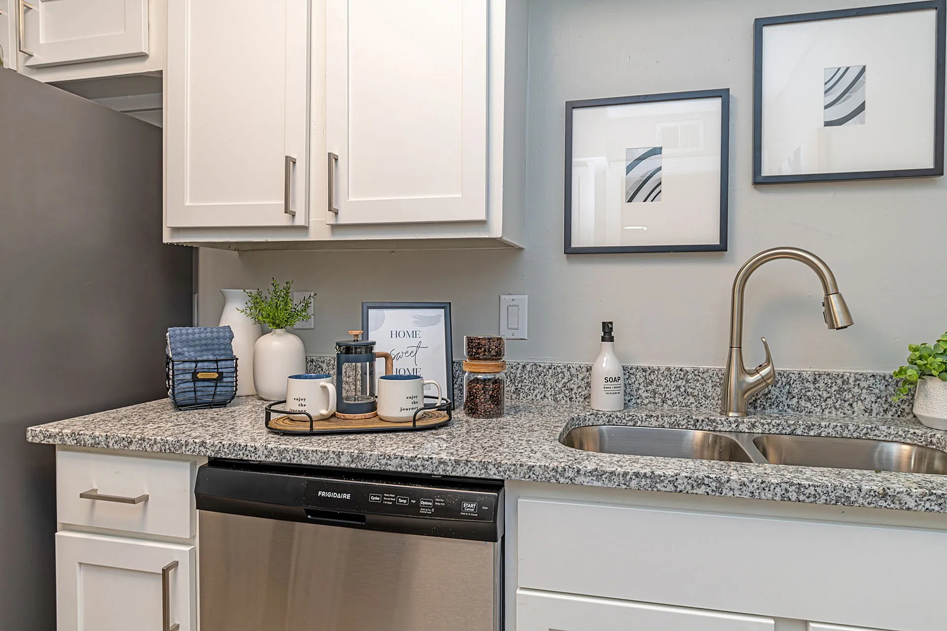 Modern kitchen corner with sleek granite countertops, elegant cabinetry, and chic decor, perfect for a stylish, welcoming home.