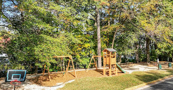 A playground with a basketball hoop and a slide.at Waverly Manor Townhomes, Norcross, GA 30071