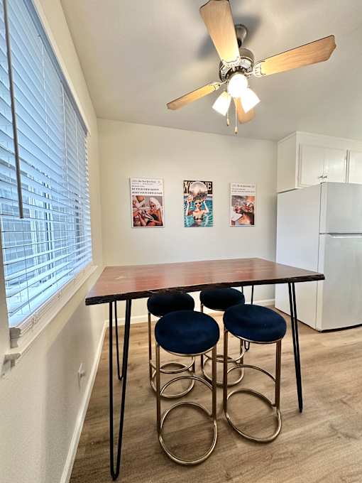 a dining area with a table and four chairs and a kitchen with a large window