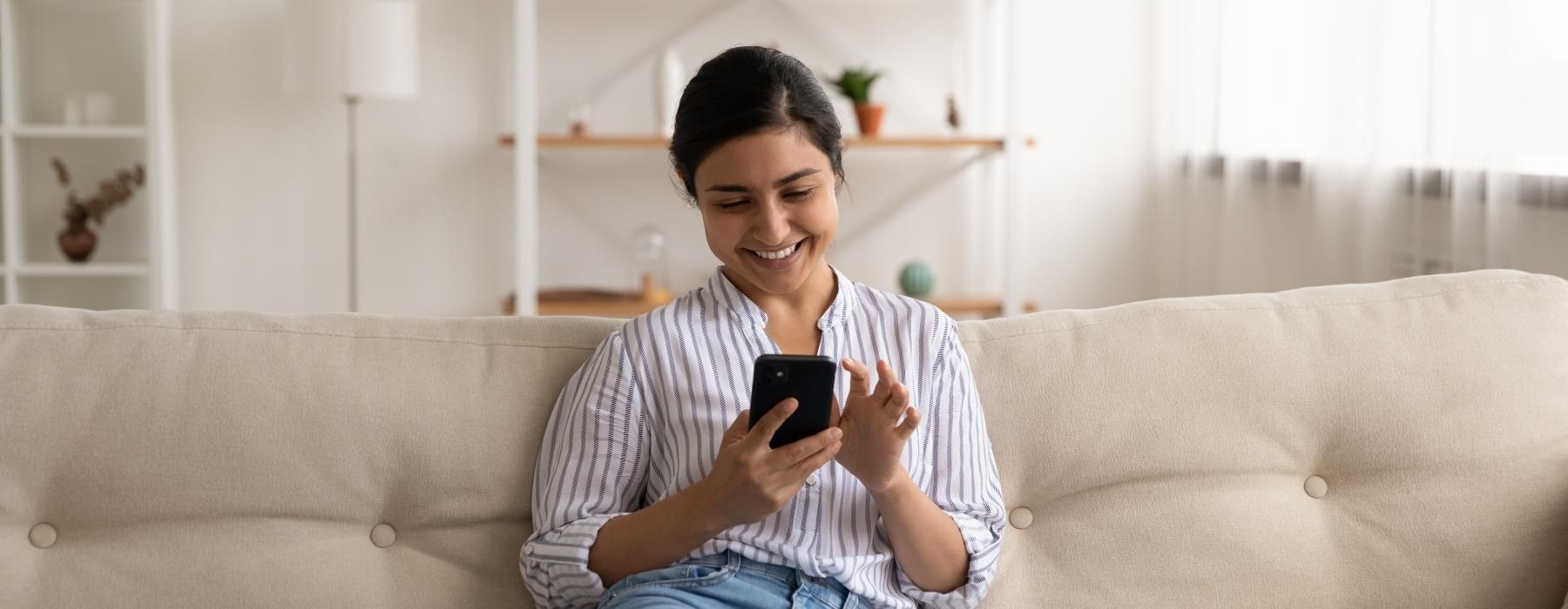 a person sitting on a couch and holding a phone