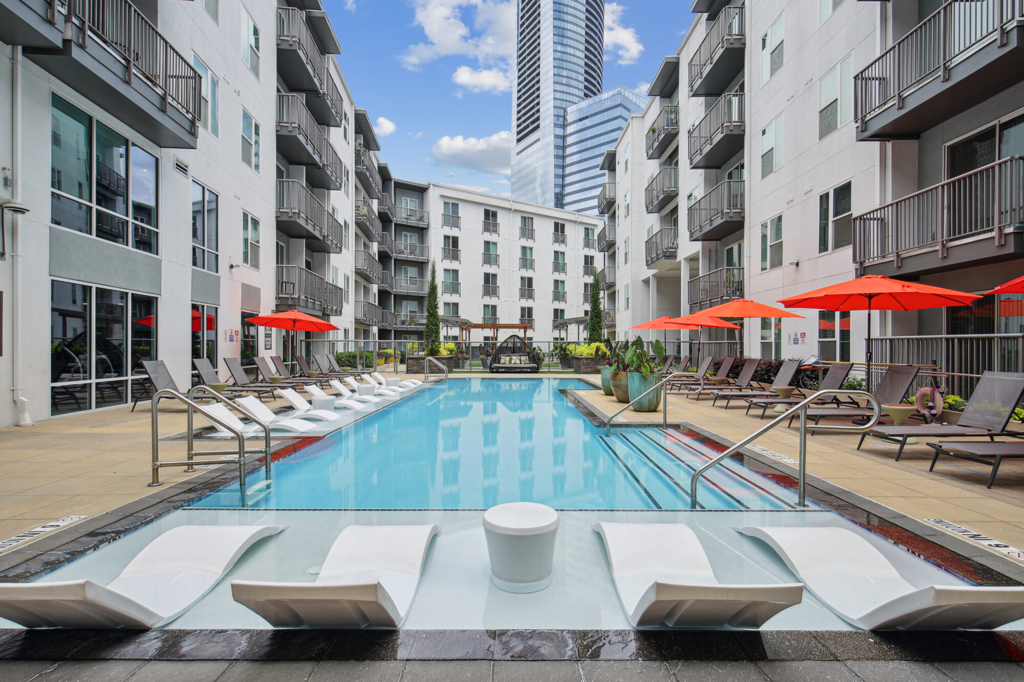 Pool with deck seating and umbrellas