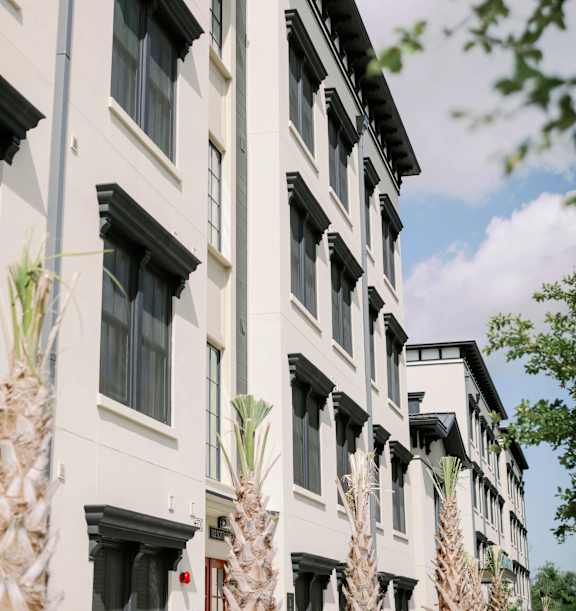 a row of apartment buildings on a city street at The Merchant Apartments, Charleston, 29403