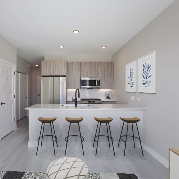 a kitchen with a large island with three bar stools