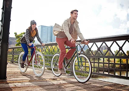 woman and man on a bike on a bridge