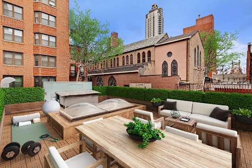 A patio with a table and chairs is surrounded by a brick building.
